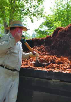 AU Facilities employee spreads mulch on campus