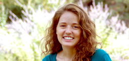 College of Agriculture student, Emily Brennan, sitting outside in a garden.