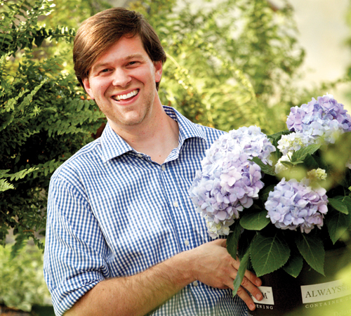 College of Agriculture alumnus, James T. Farmer III holds a bucket of blue hydrangeas.