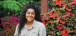 Molly Anne Dutton sitting in front of colorful flowers at the Biltmore Estate.