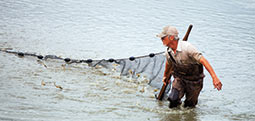 David Teichert-Coddington in a pond harvesting shrimp (Photo by Tom Sizemore/John Deere)