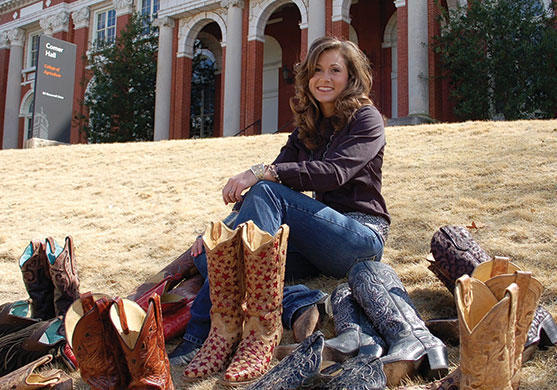 Lauren Terry posing on the front lawn of Comer Hall with her cowboy boot collection