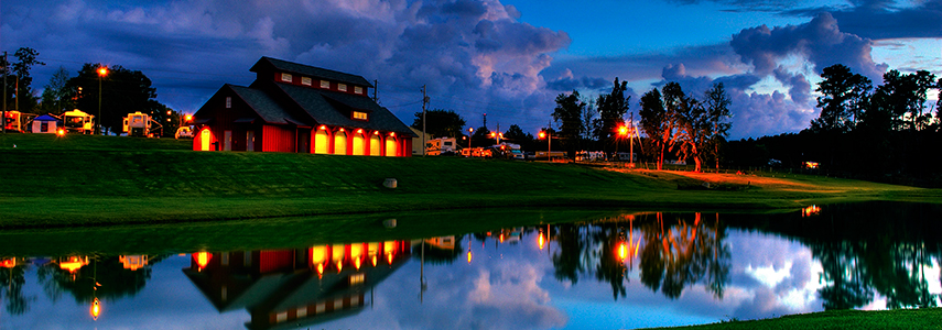 Pavilion and pond at Ag Heritage Park at night surrounded by RVs.
